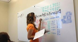 Photo of person writing on white board